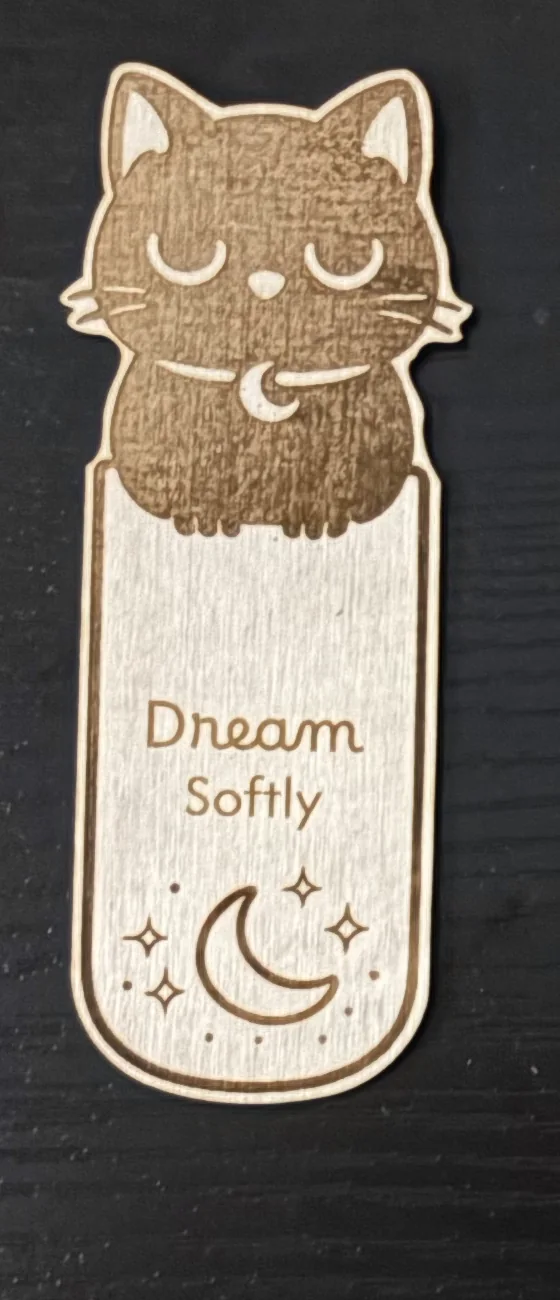 Completed basswood bookmark engraved with a sleeping cat and the words Dream Softly.